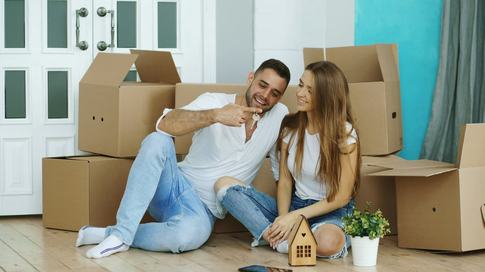 A couple sitting among moving boxes in their new home