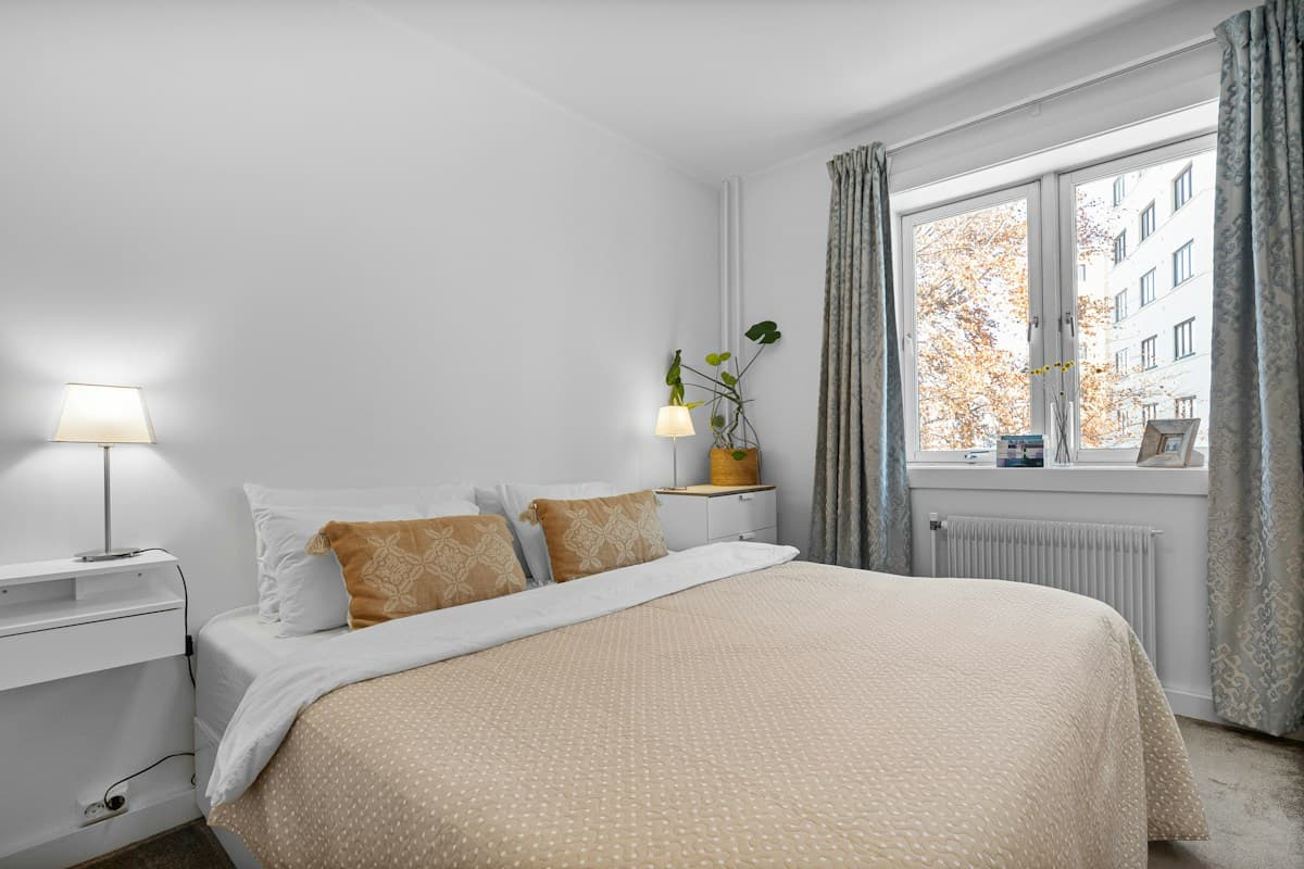 A simple, tidy apartment bedroom with a window